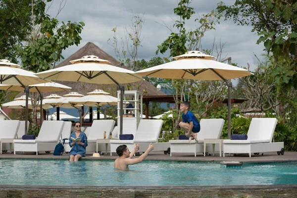 풀만 루앙프라방 호텔 야외 수영장에서 물놀이 중인 가족 모습